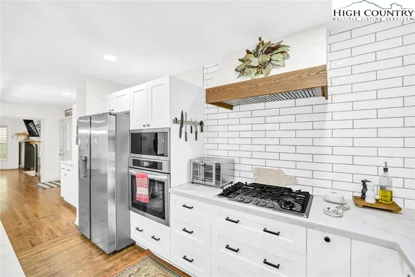 a kitchen with stainless steel appliances kitchen island granite countertop a refrigerator and a stove