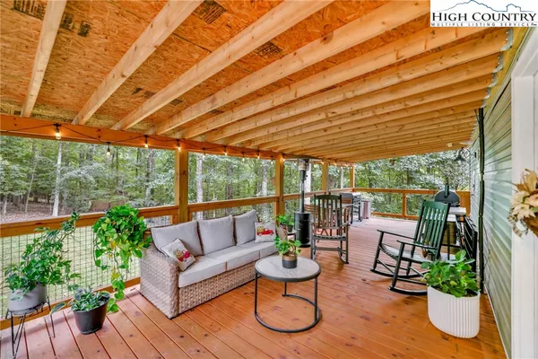 a roof deck with couches and potted plants