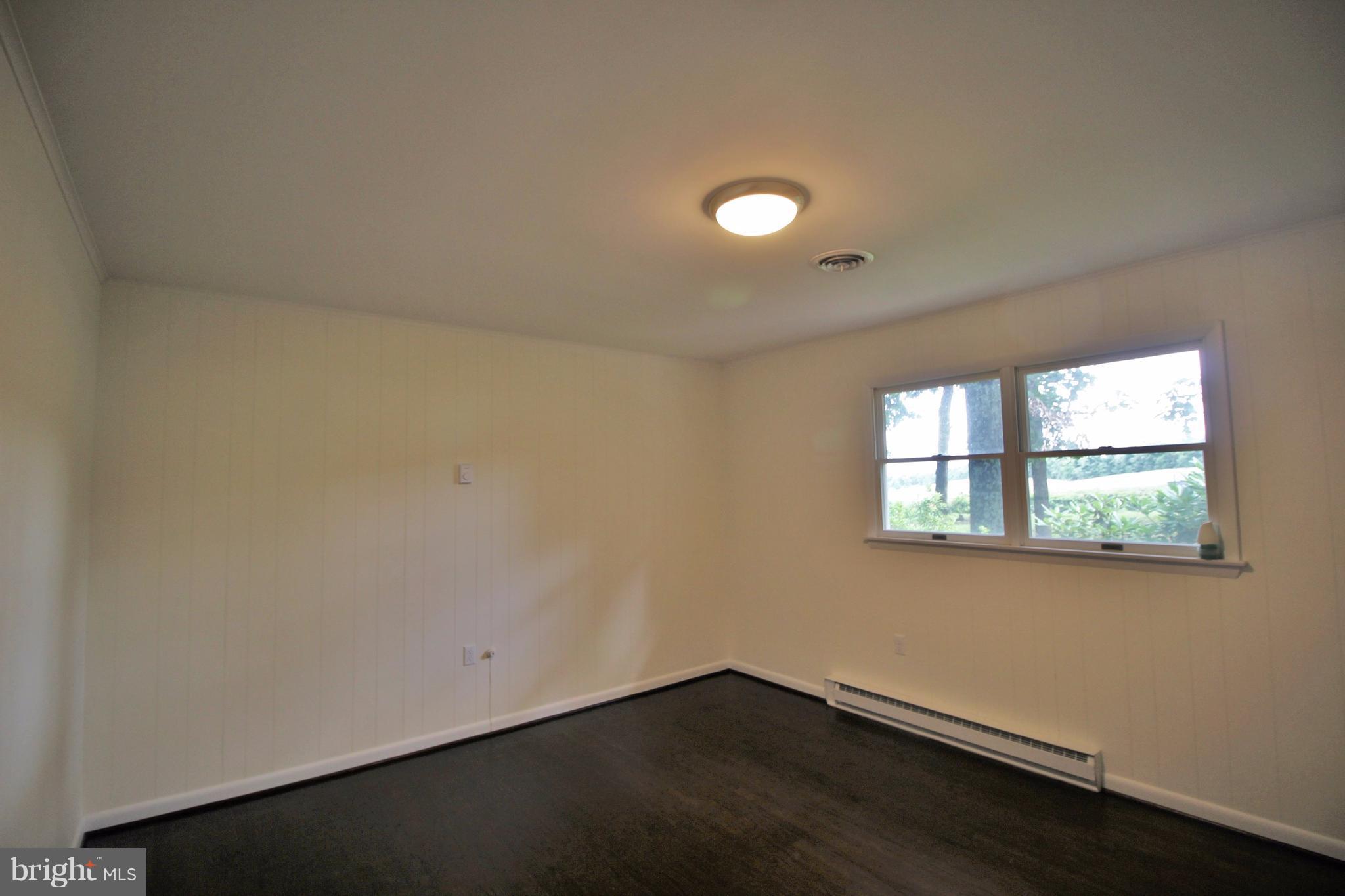 12919 Old Annapolis Road Mount Airy, MD 21771 - Photo 13 of 30 an empty room with wooden floor and windows
