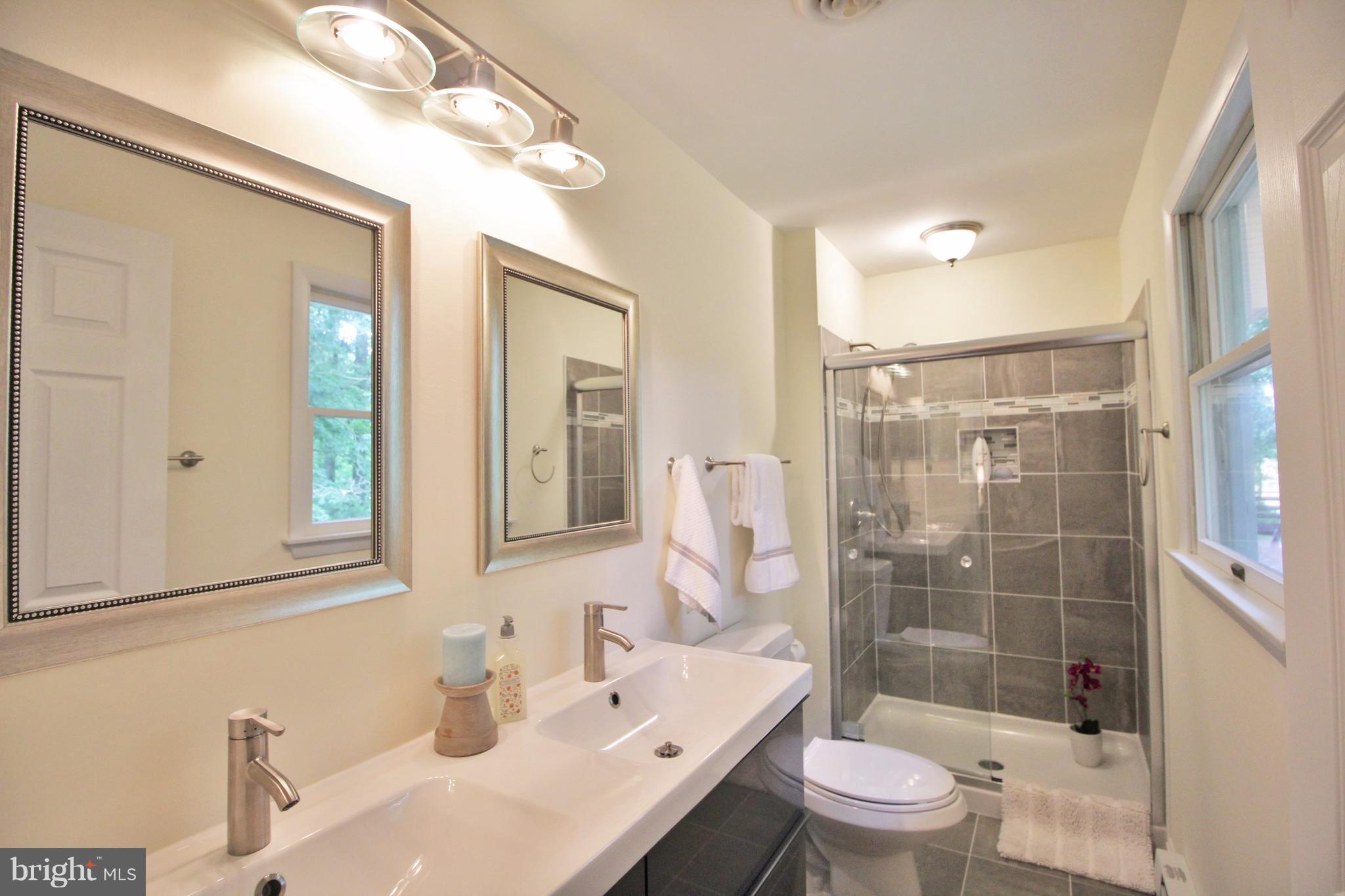 12919 Old Annapolis Road Mount Airy, MD 21771 - Photo 17 of 30 a bathroom with a sink a toilet a mirror a vanity and shower