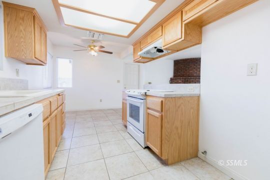 929 South Ranger Street Ridgecrest, CA 93555 - Photo 9 of 25 a kitchen with a stove top oven cabinets a sink and a window