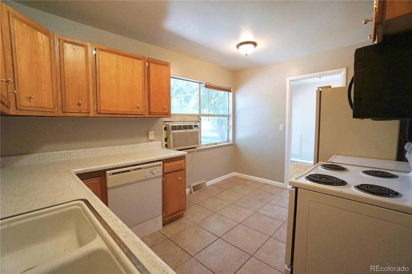 2519 15th Avenue Greeley, CO 80631 - Photo 11 of 25 a kitchen with stainless steel appliances granite countertop a stove a sink and a refrigerator