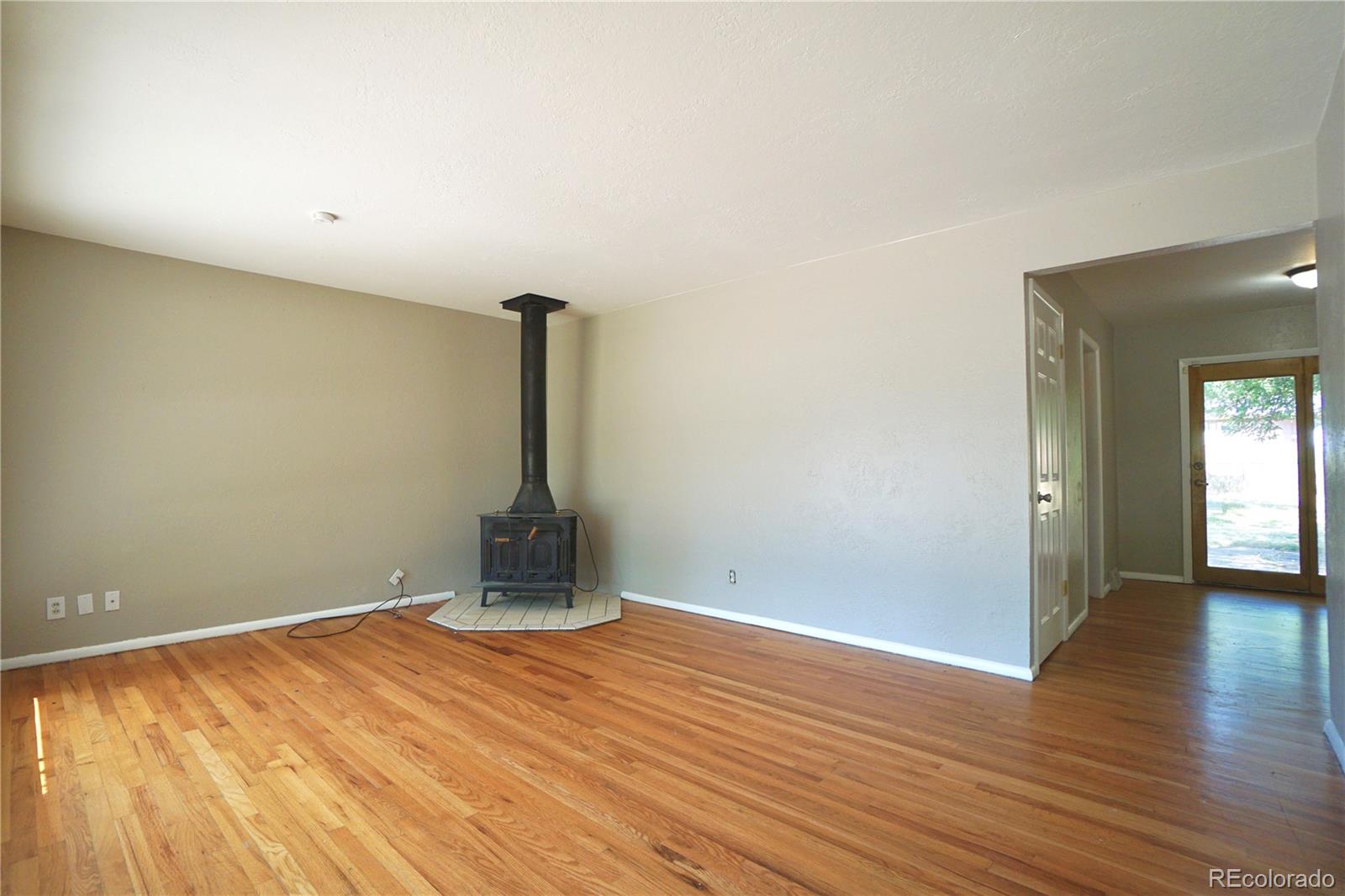 2519 15th Avenue Greeley, CO 80631 - Photo 6 of 25 a view of an empty room with wooden floor and a window