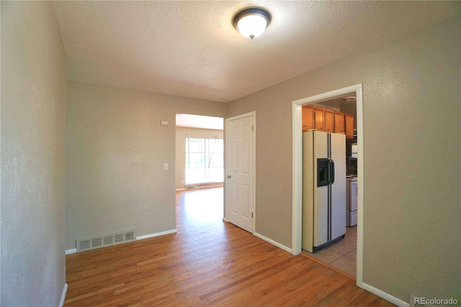 2519 15th Avenue Greeley, CO 80631 - Photo 9 of 25 an empty room with wooden floor and windows