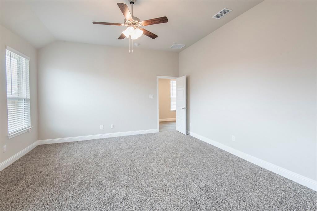 2301 Ruff Road Denton, TX 76205 - Photo 12 of 23 Spacious room featuring vaulted ceilings, a ceiling fan with integrated lighting, broad window with blinds, plush gray carpeting, and painted interior walls