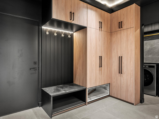 2610 Foxridge Road Garden City, UT 84028 - Photo 33 of 71 Wood-finish cabinetry with black hardware, integrated task lighting, black slat wall paneling, and a stone-finish bench