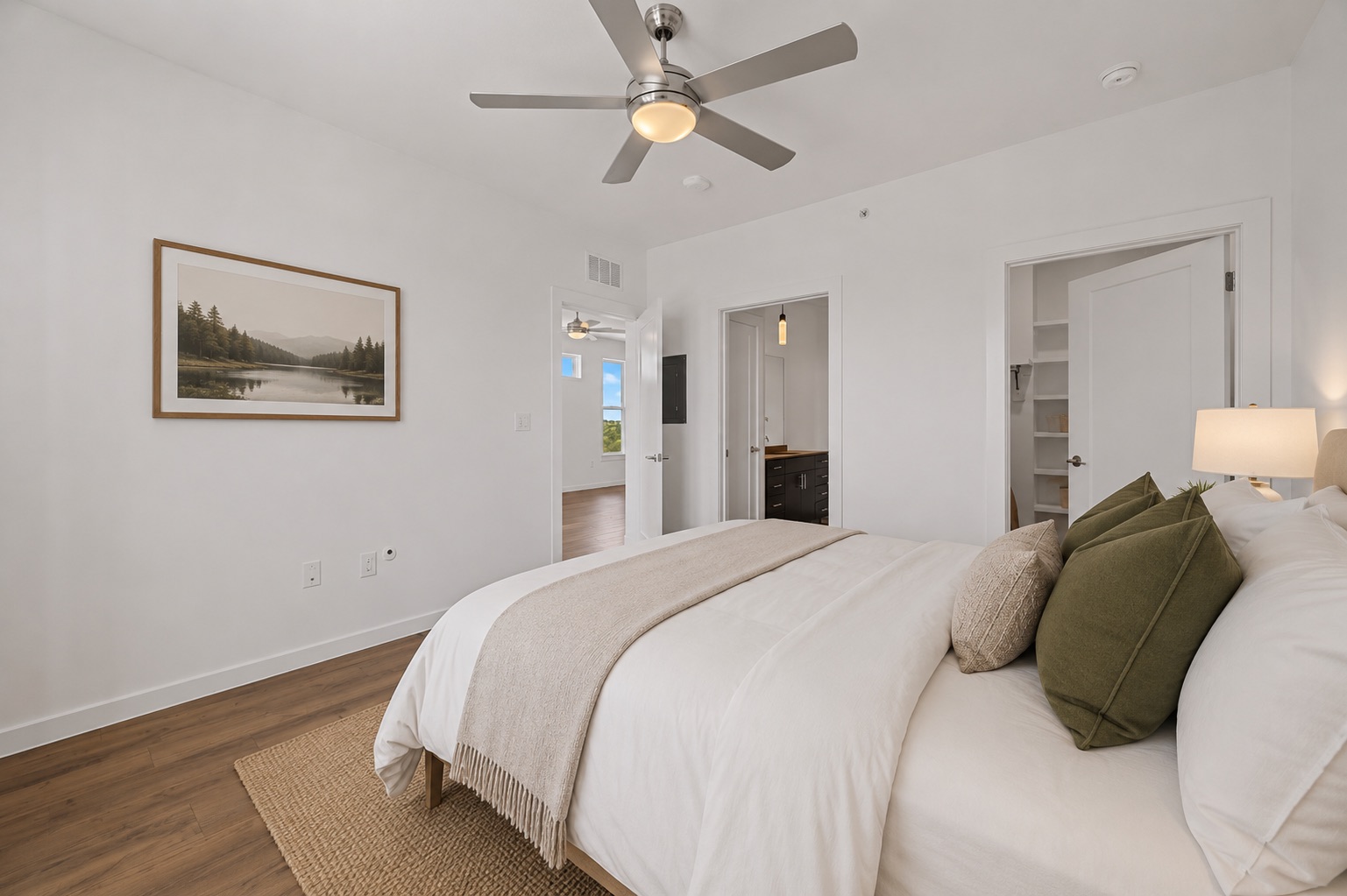 4801 Springdale Road, Unit 2301 Austin, TX 78723 - Photo 14 of 36 A well-lit bedroom features hardwood flooring and a functional ceiling fan, offering both comfort and modern convenience.
