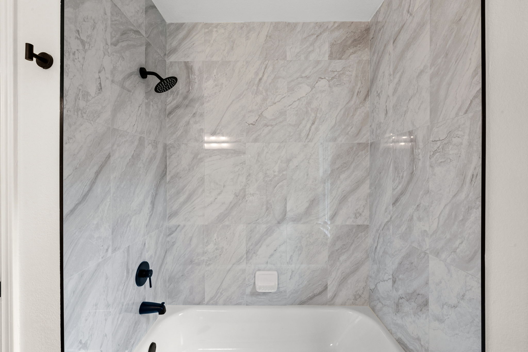 909 Rocking Spur Cove Pflugerville, TX 78660 - Photo 29 of 33 A well-appointed bathroom features a bathtub and shower area with elegant tiled walls.