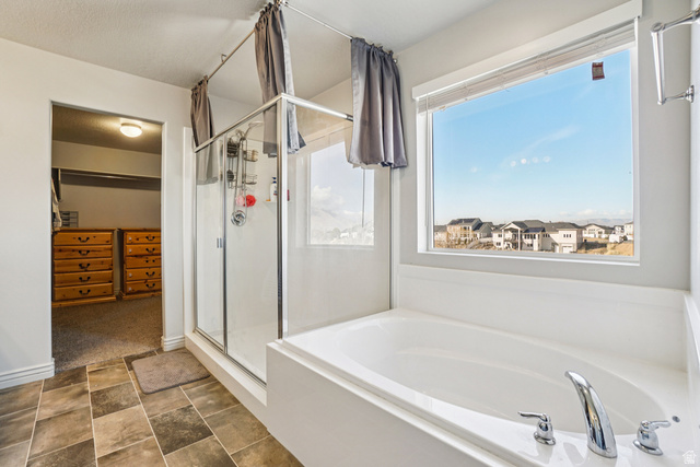 203 North 1900th Street West Mapleton, UT 84664 - Photo 18 of 48 Bathroom featuring a built-in soaking tub with chrome fixtures, a glass-enclosed shower, and multi-toned tile flooring