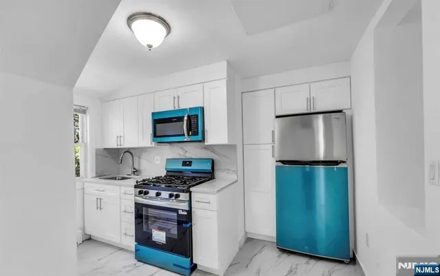 a kitchen with a refrigerator and a stove