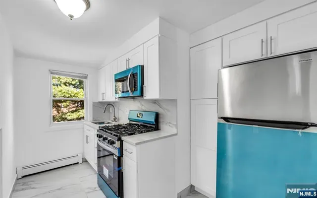 a kitchen with stainless steel appliances a refrigerator sink and stove