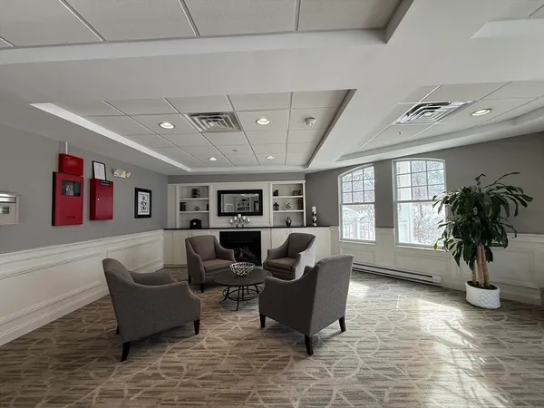 a living room with furniture a chandelier and a potted plant