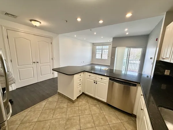 a large kitchen with stainless steel appliances granite countertop a sink and cabinets