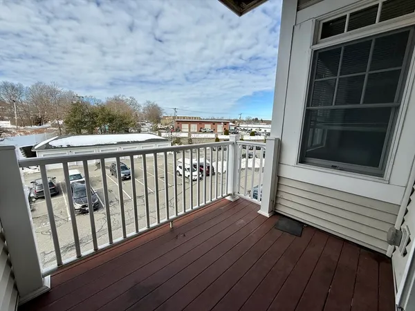 a view of a balcony with wooden floor and fence