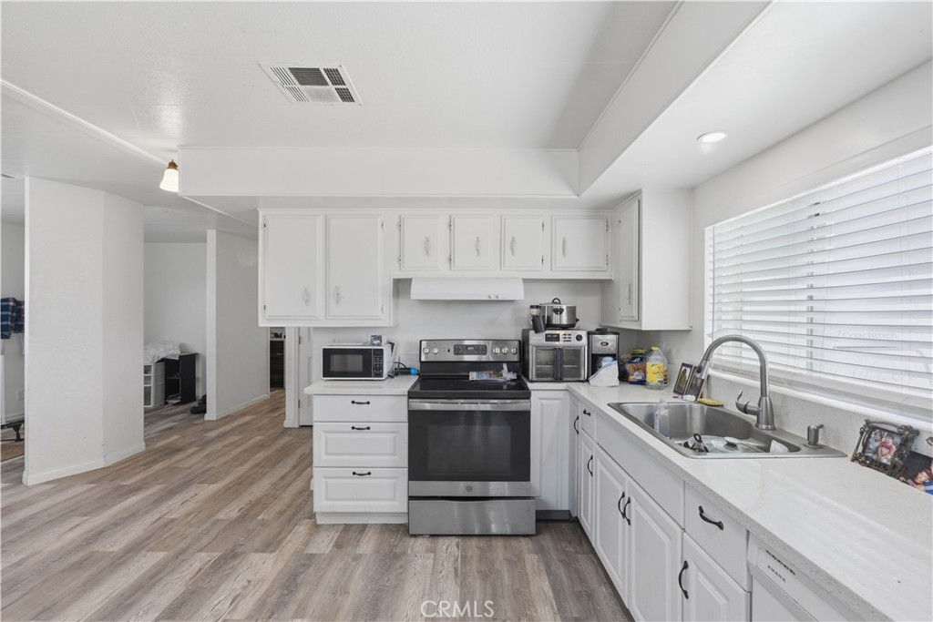 5885 Dos Palmas Road Phelan, CA 92371 - Photo 12 of 40 a kitchen with stainless steel appliances a stove sink and cabinets