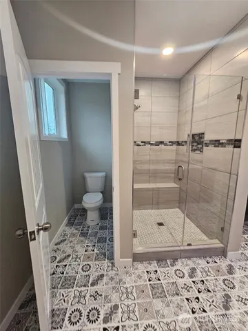 a bathroom with a toilet and a shower