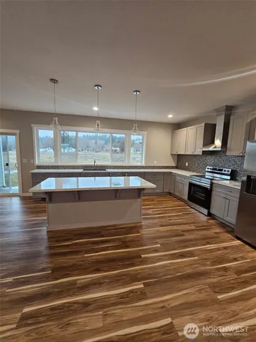 a large kitchen with stainless steel appliances granite countertop a stove and a sink