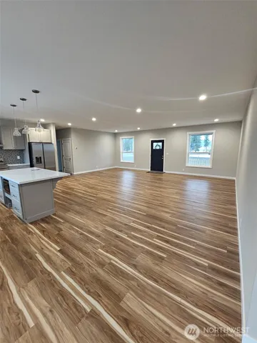 a view of a kitchen with kitchen island and stainless steel appliances