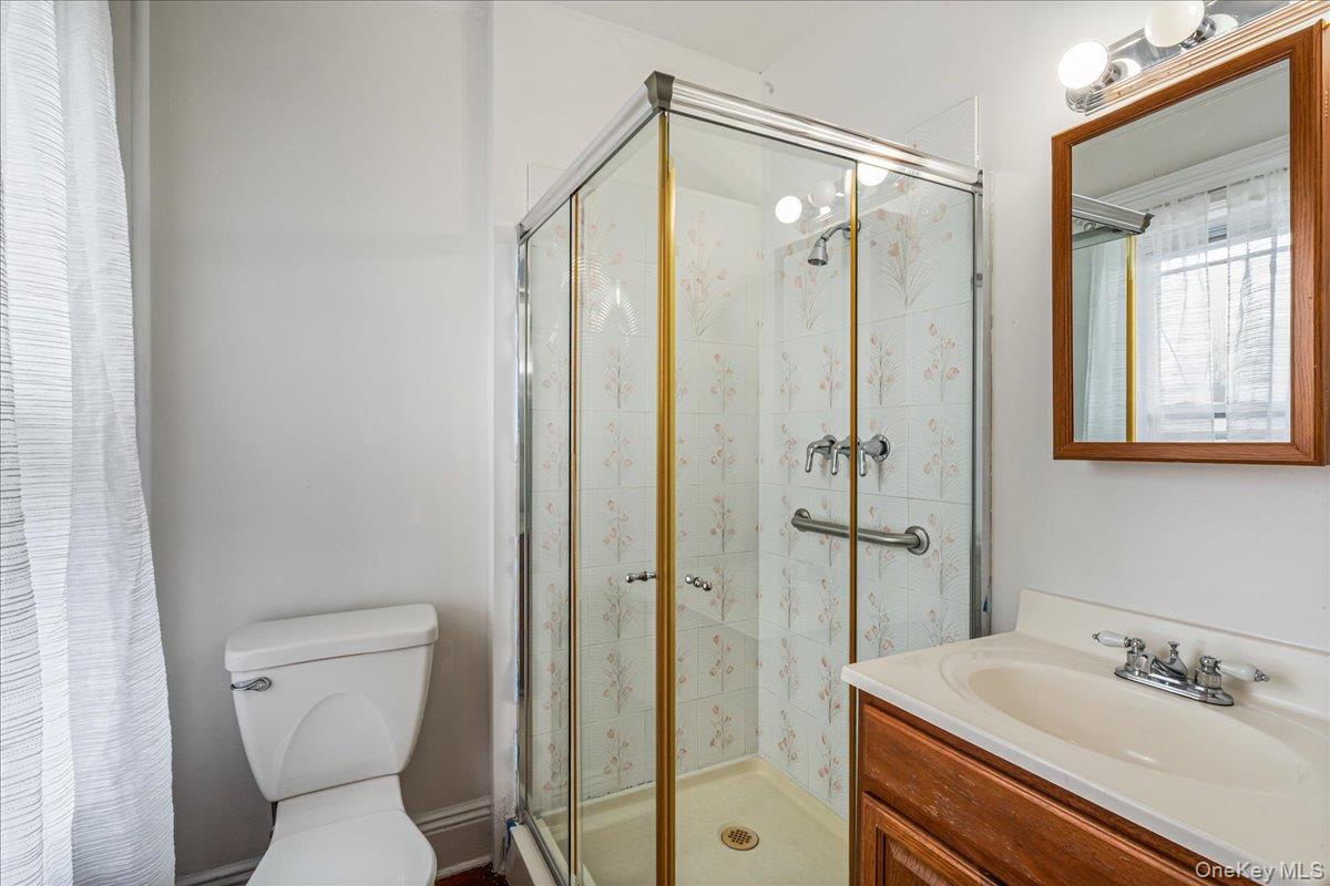 196-19 89th Road Queens, NY 11423 - Photo 13 of 28 a bathroom with a shower sink vanity and toilet