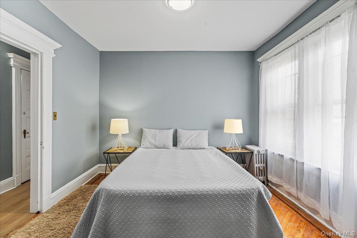 196-19 89th Road Queens, NY 11423 - Photo 14 of 28 a bedroom with a bed and a large window