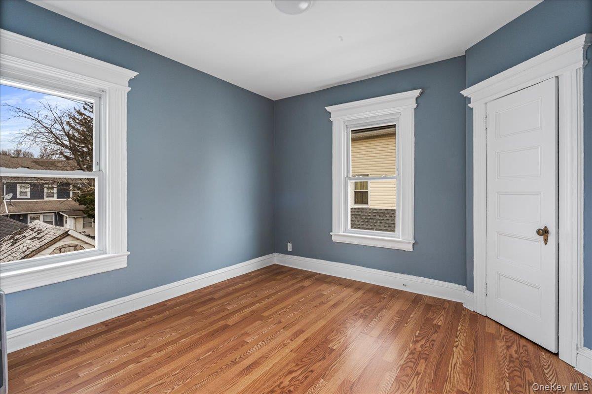 196-19 89th Road Queens, NY 11423 - Photo 16 of 28 a view of an empty room with window and wooden floor
