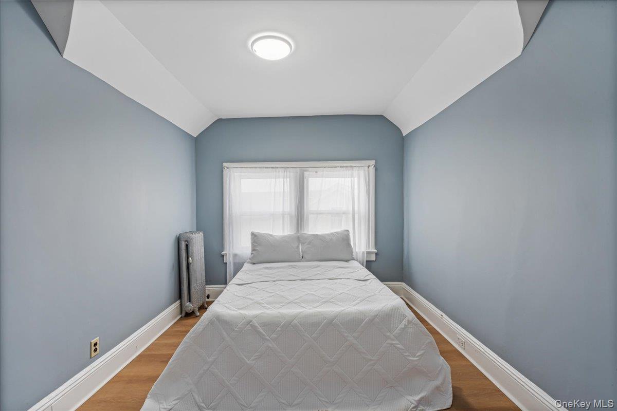 196-19 89th Road Queens, NY 11423 - Photo 17 of 28 a bedroom with a bed and a window