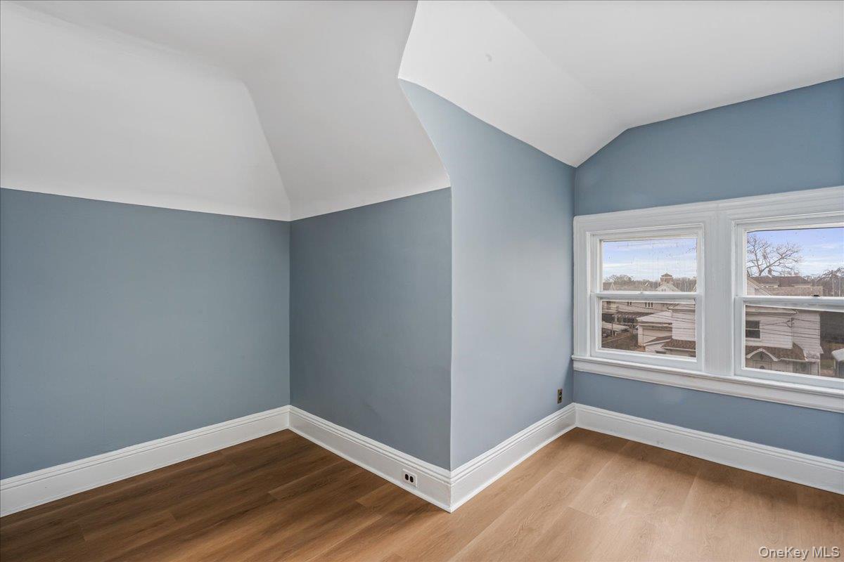 196-19 89th Road Queens, NY 11423 - Photo 20 of 28 a view of an empty room with wooden floor and a window
