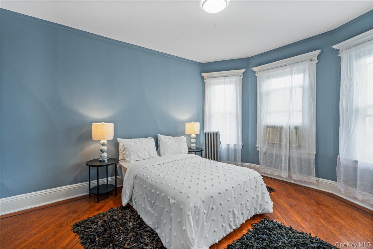 196-19 89th Road Queens, NY 11423 - Photo 10 of 28 a bedroom with a bed and wooden floor