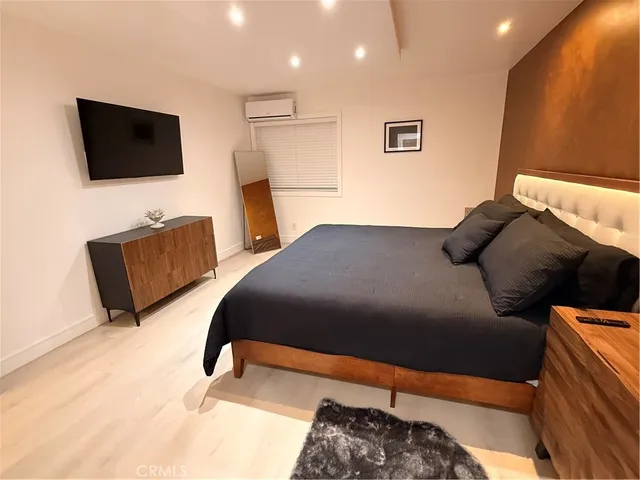 a bedroom with a bed and a flat screen television