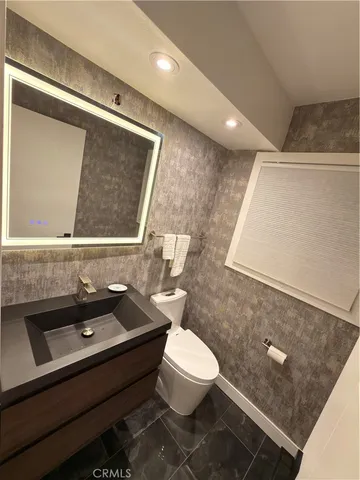 a bathroom with a sink a toilet a mirror and vanity