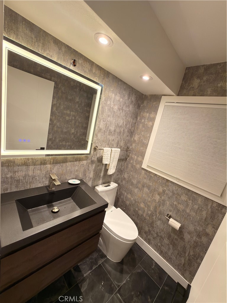 1140 Pacific Avenue, Unit 7 Long Beach, CA 90813 - Photo 17 of 21 a bathroom with a sink a toilet a mirror and vanity