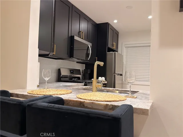 a kitchen with granite countertop a sink and a stove top oven
