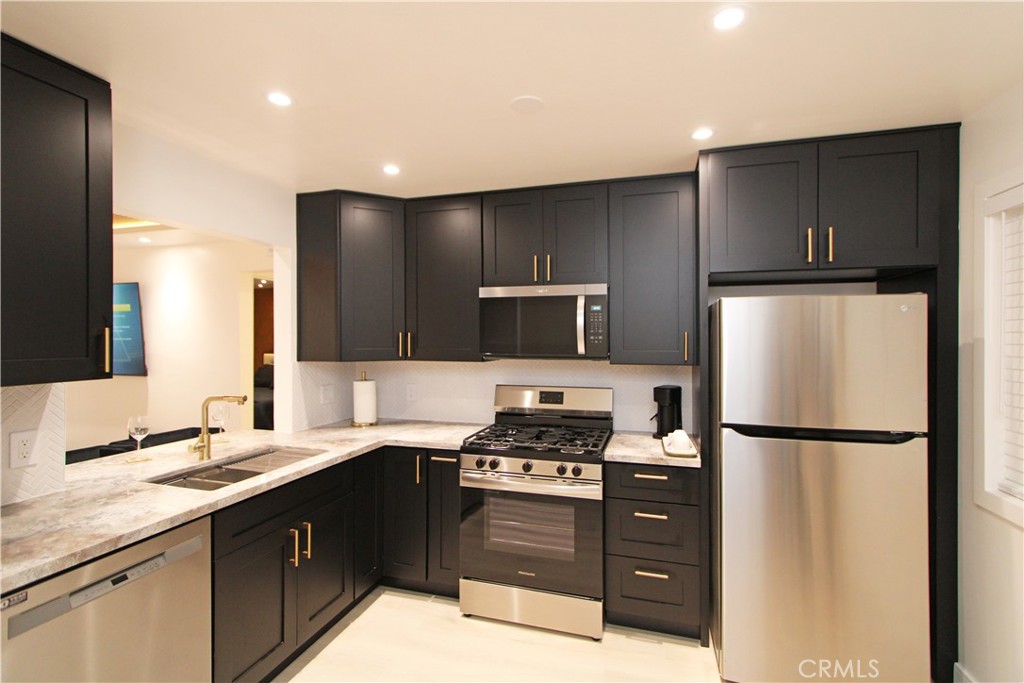 1140 Pacific Avenue, Unit 7 Long Beach, CA 90813 - Photo 6 of 21 a kitchen with a refrigerator sink and cabinets