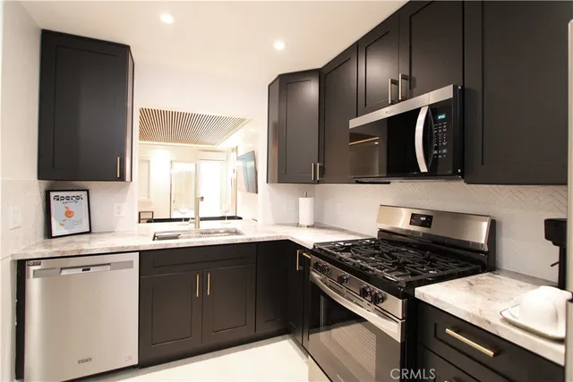 a kitchen with stainless steel appliances a sink stove and microwave