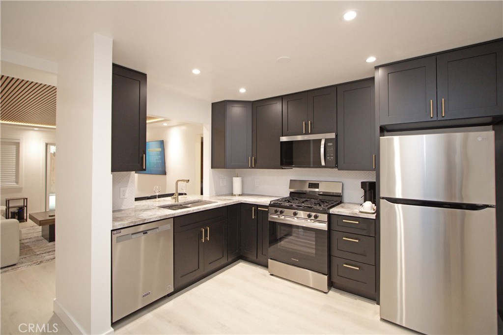 1140 Pacific Avenue, Unit 7 Long Beach, CA 90813 - Photo 8 of 21 a kitchen with stainless steel appliances granite countertop a refrigerator stove a sink and a microwave