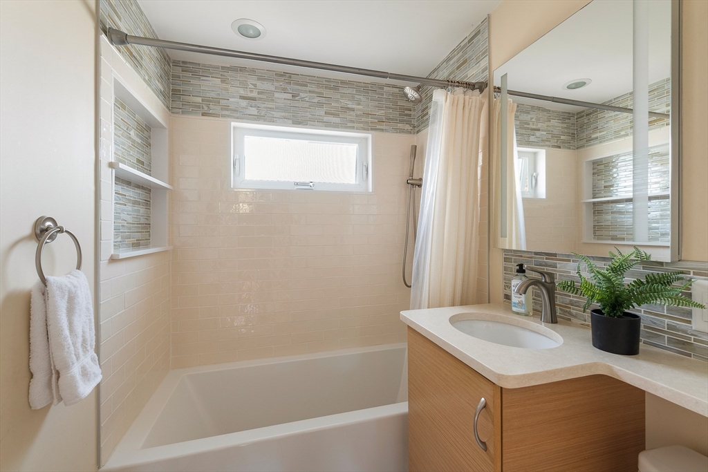 75 Fremont Street Arlington, MA 02474 - Photo 15 of 20 a bathroom with a granite countertop sink a mirror and a shower