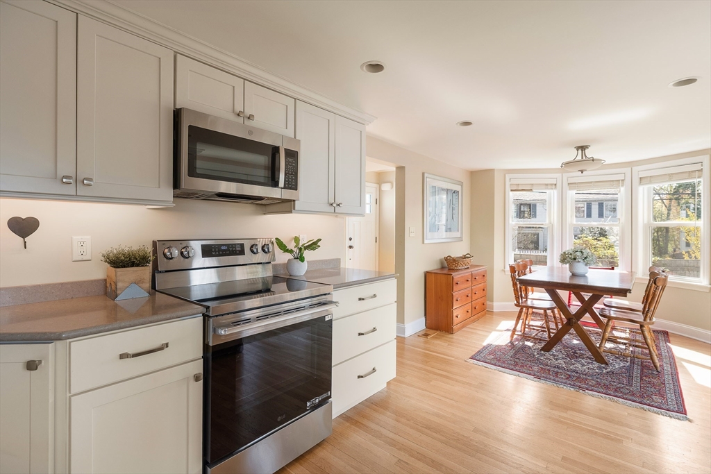 75 Fremont Street Arlington, MA 02474 - Photo 7 of 20 a kitchen with stainless steel appliances granite countertop a stove a sink dishwasher a microwave oven and white cabinets with wooden floor