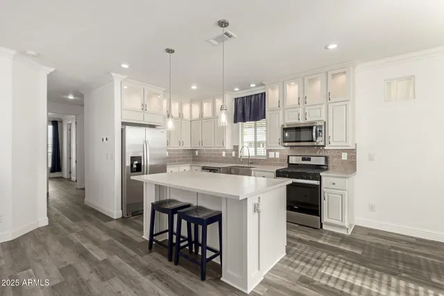 a kitchen with white cabinets and stainless steel appliances