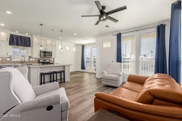 a living room with furniture kitchen and a wooden floor