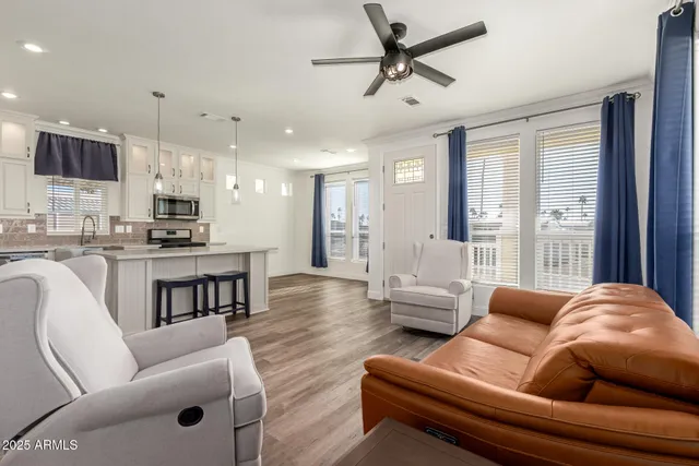 a living room with furniture kitchen and a wooden floor