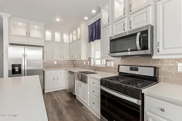 a kitchen with stainless steel appliances granite countertop a stove microwave sink and refrigerator