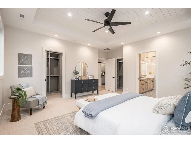 a bedroom with a bed a table and chair with the wooden floor