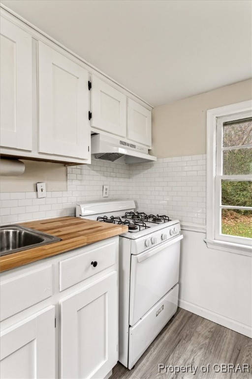 10370 Maryus Road Hayes, VA 23072 - Photo 21 of 35 Kitchen featuring exhaust hood, decorative backsplash, white gas stove, light hardwood / wood-style floors, and white cabinetry