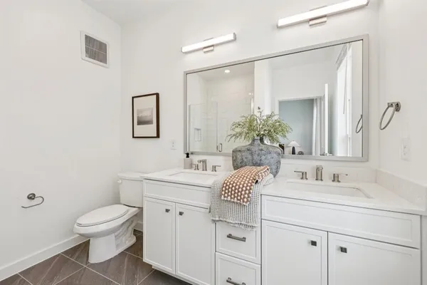 a bathroom with a toilet a sink and mirror