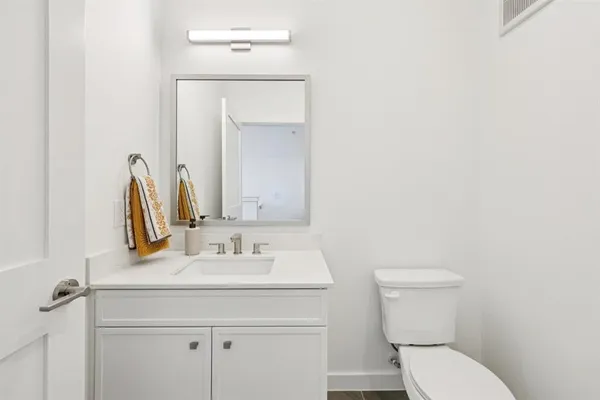 a bathroom with a toilet sink and mirror