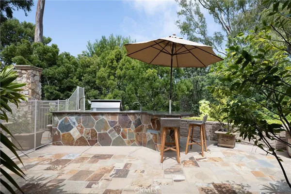 a view of a chair and table with umbrella in the patio