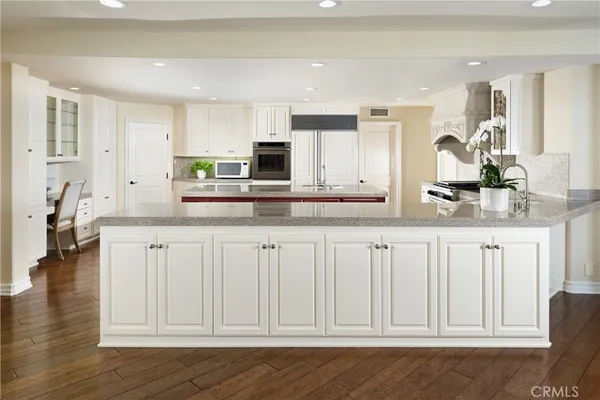 a kitchen with white cabinets and sink