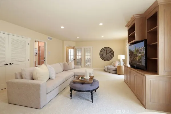 a living room with furniture a window and a flat screen tv
