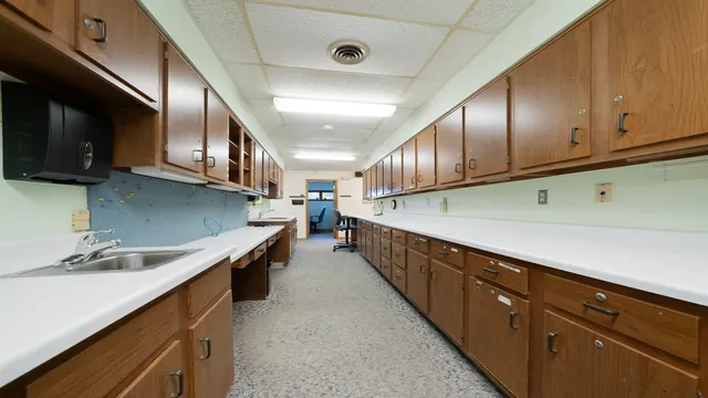 a kitchen with stainless steel appliances granite countertop a sink a stove and a wooden cabinets