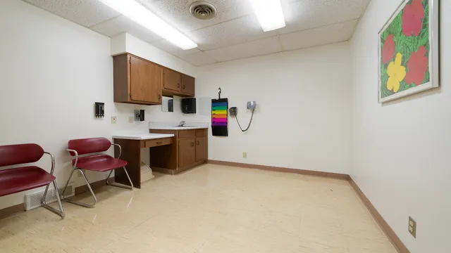 a view of a workspace with furniture and a window